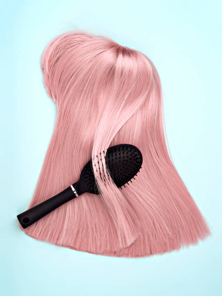 istock Black hair brush and pink wig. 1216085834