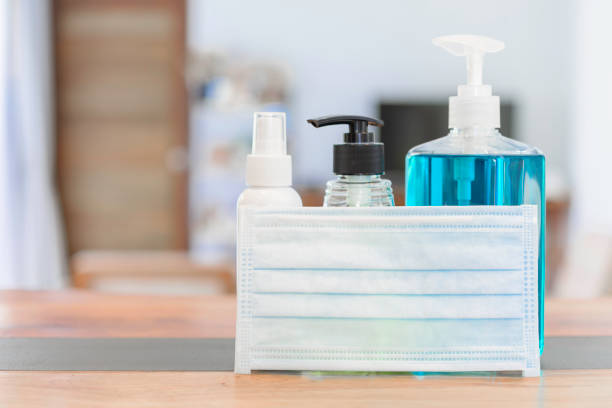 istock Coronavirus germ protective with  masks  and gel alcohol or hand sanitizer spray bottle for washing hand  to protect corona virus set on wood table in home 1216086844