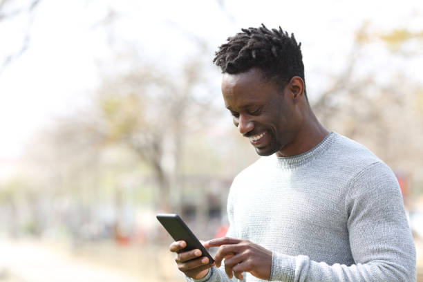 istock Happy black man using smart phone in a park 1216087087