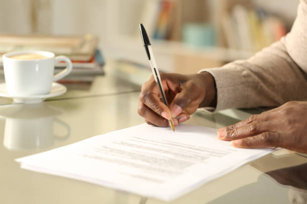 istock Black man hands singing contract on a desk 1216087093