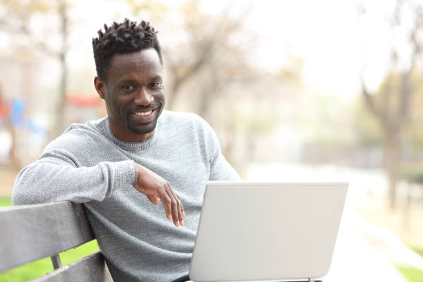 istock Happy black man with laptop looking at camera 1216087103