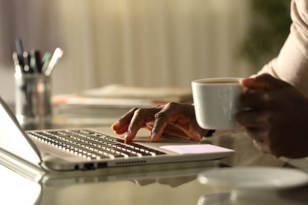 Black man hands using laptop in the night at home