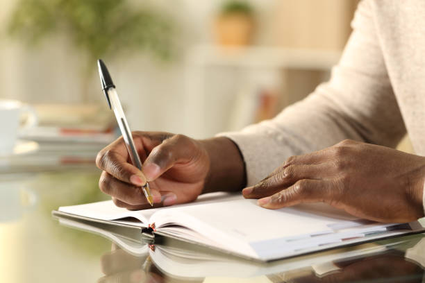 istock Black man hands writing reminder on agenda 1216087843