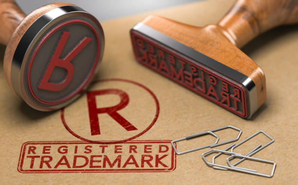 Registered Trademark Concept 3D illustration of two rubber stamps with the text registered trademark and the symbol R over brown paper background. Trade-mark Registration Concept intellectual property stock pictures, royalty-free photos & images