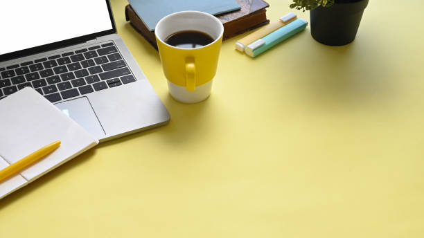 istock Top view image of colorful workplace that full of document, coffee cup, notebook, pen, marker pens and computer laptop with white empty screen. 1216089857