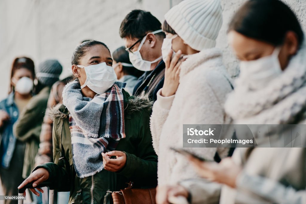 As long as we're together we'll get through this Shot of a young man and woman wearing masks while travelling in a foreign city Protective Face Mask Stock Photo