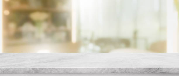 istock Empty white marble stone table top and blur glass window interior restaurant banner mock up abstract background - can used for display or montage your products. 1216093332