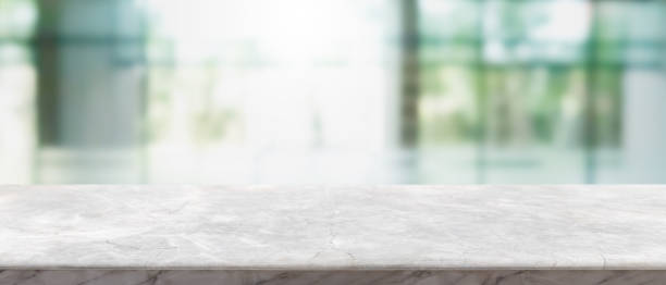 istock Empty white marble stone table top and blur glass window interior lobby and hall way banner mock up abstract background - can used for display or montage your products. 1216093335
