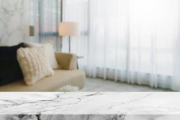 istock Empty white marble stone table top and blurred living room in home interior with curtain window background. - can used for display or montage your products. 1216093353