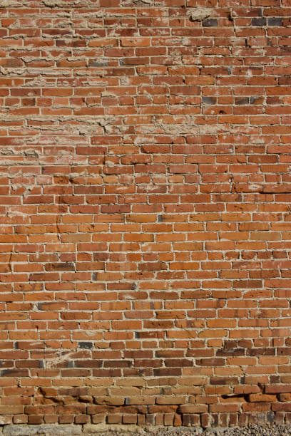 istock Charming old clay brick wall background with erosion from age 1216094621