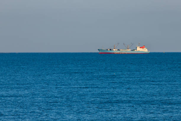 istock freight ship sailing on the horizon blue tones 1216094763