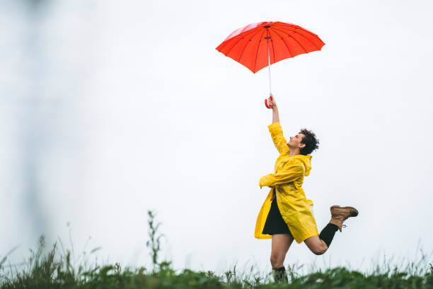 istock Woman holding umbrella on wind 1216099944