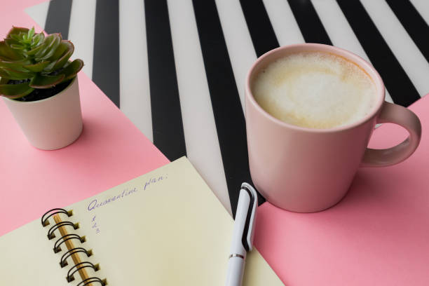 istock Self isolation concept. Open notepad with quarantine plan during coronavirus pandemia. Pink cup of capuccino on a table 1216100356