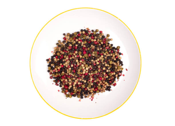 istock Peper background, white, green, black and red peper on a white plate, isolated on white 1216101179
