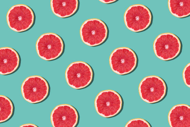 istock Tasty ripe grapefruit slices on blue background 1216101223