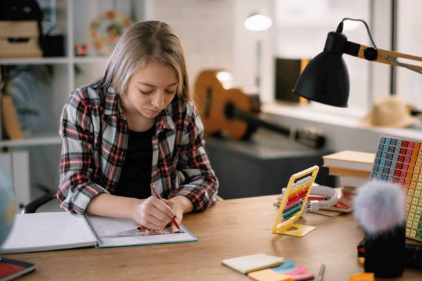 istock Little girl doing homework in home. 1216103528