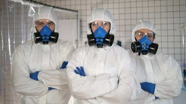 istock Doctors in a protective clothes standing together with arms crossed 1216106834