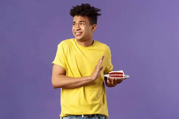 Celebration, party and holidays concept. Oh gosh its disgusting. Portrait of reluctant and displeased young man turn away from awful bad taste cake, show refusal, rejection or stop sign.