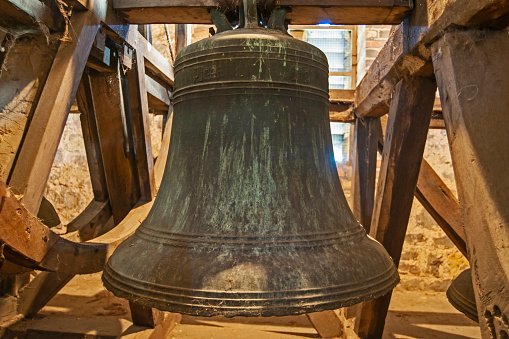 Traditional large old bells hanging in an english church tower from the middle ages