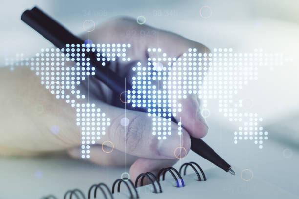 istock Abstract creative digital world map and man hand writing in diary on background, globalization concept. Multiexposure 1216107989