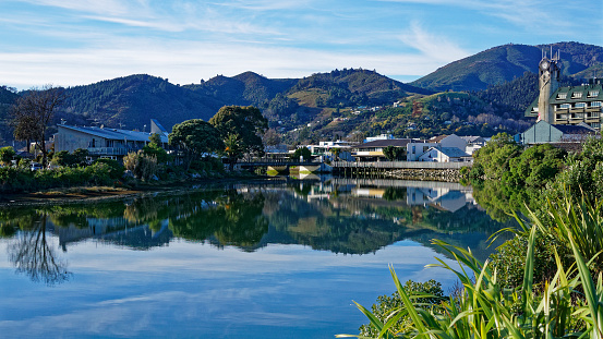 Panorama of Nelson City, reflected in the still waters of the Maitai River, New Zealand.