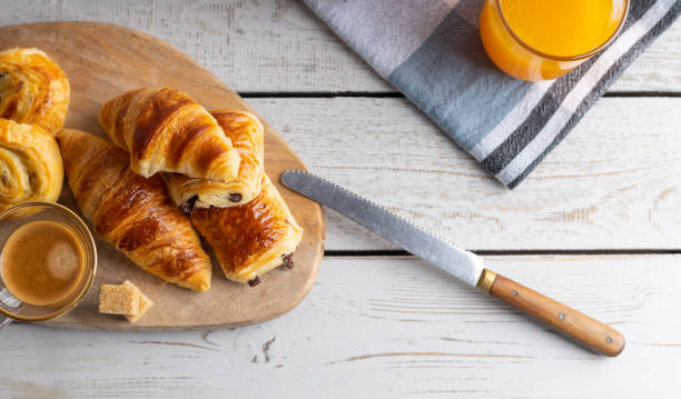 istock Breakfast table with croissants and cinnamon buns with fresh orange juice. 1216108760