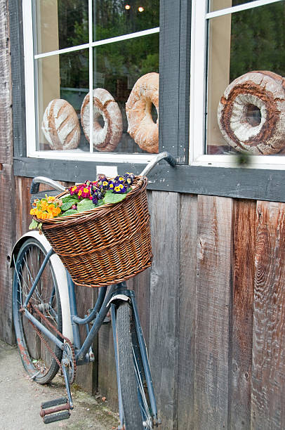 Fresh crispy baguettes in a beautiful basket in a cafe. Wicker basket with baguettes. Many rows of clean tea cups on a table in a bakery cafe