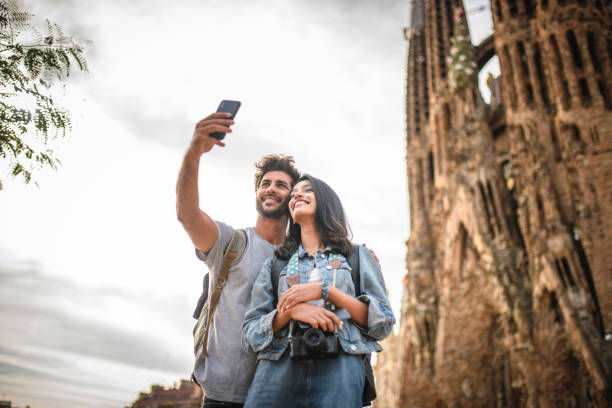 vacationing young couple taking selfie at sagrada familia - l unesco imagens e fotografias de stock