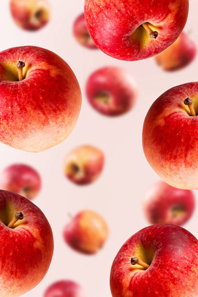 istock Falling large ripe red apples background. Close-up. 1216113307