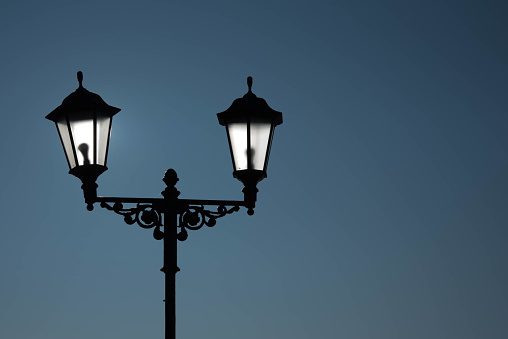 Beautiful old lantern lighting on blue sky background. Street Lamp. Street retro lantern on blue background .