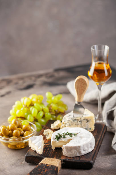 ser brie i dorblu lub gorgonzola na desce z winogron i oliwek. włoski antipasti żywności - grappa photography food and drink vertical zdjęcia i obrazy z banku zdjęć