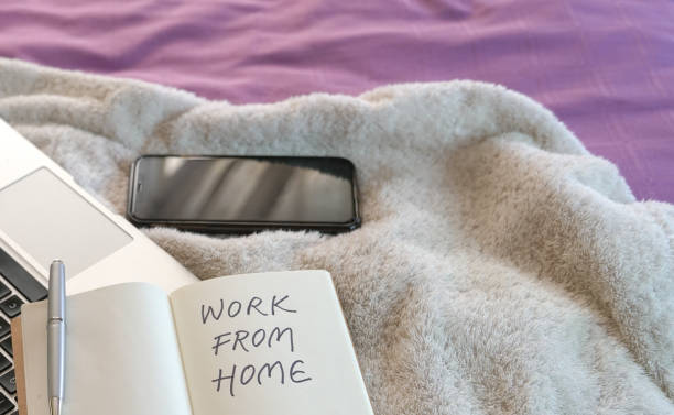istock Work from home. Laptop, cellphone and notepad on the bed 1216124583
