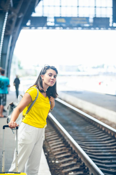 istock woman at railway station waiting for train 1216124677