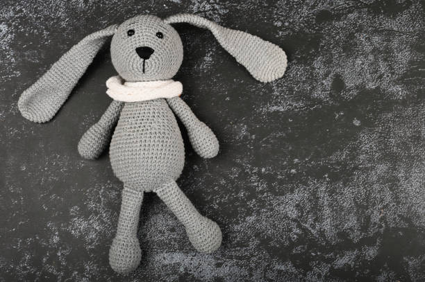 istock Gray knitted hare on a dark background. Black easter concept. Black eggs. Easter for black people 1216124844