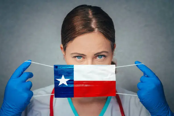 Photo of Coronavirus in U.S. State Texas, Female Doctor Portrait, protect Face surgical medical mask with Texas Flag. Illness, Virus Covid-19 in Texas
