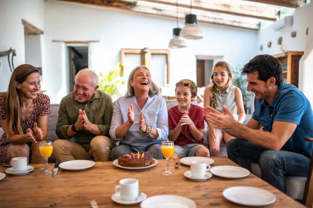 istock Lighthearted Senior Woman Claps After Blowing Out Candles 1216130088