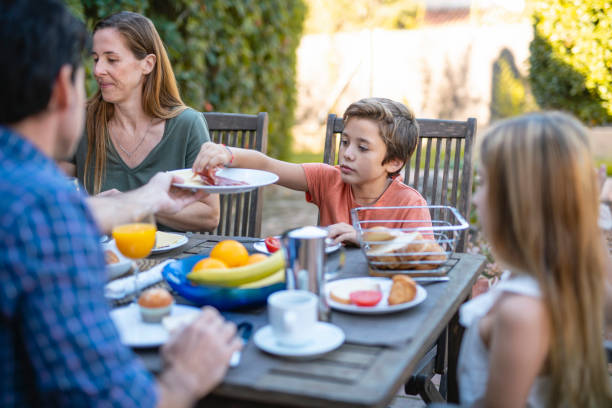 istock Father Sharing Prosciutto and Cheese with Son at Breakfast 1216131164