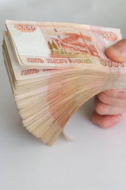 istock Men's hands hold a large number of banknotes in a pack 1216132639