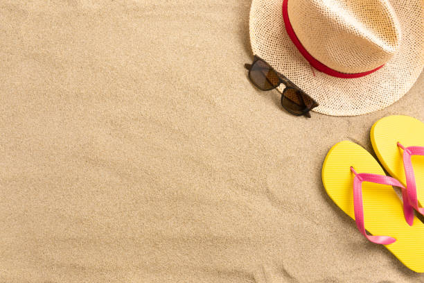 istock Straw hat and flip flops, on sand background. Beach vacation concept .Top view with copy space. 1216133402