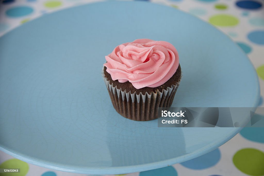 Chocolate Cupcake wPink frosting in festive setting  Blue Stock Photo