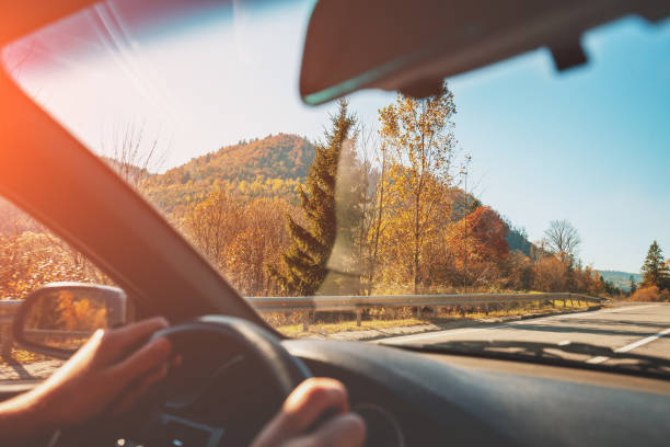 Driving a car on mountain road. Empty road on a sunny day. View from car of mountain landscape in autumn stock photo
