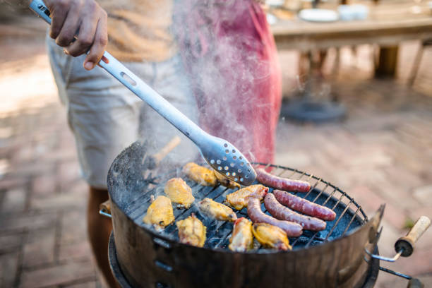 istock Couple Barbecuing Chicken and Sausage 1216134795