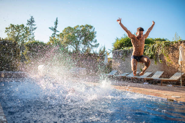 istock Energetic Young Man Jumping into Swimming Pool 1216134846