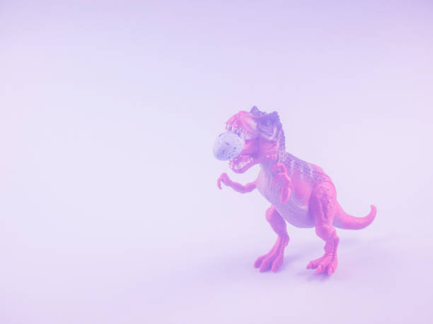 istock Angry dinosaur toy with easter egg in mouth. Toned 1216137794