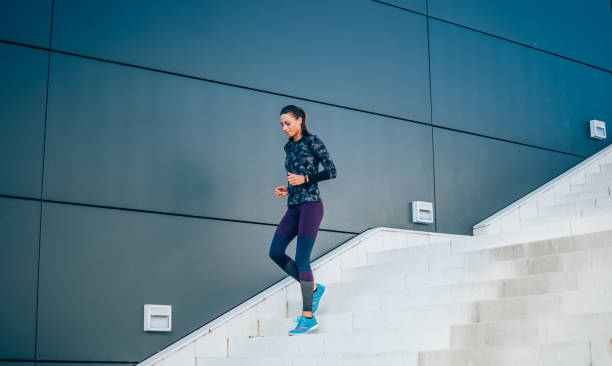 mujer corriendo por las escaleras de la ciudad. - running down fotografías e imágenes de stock