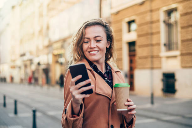 istock Cheerful woman using smart phone in the city. 1216142377