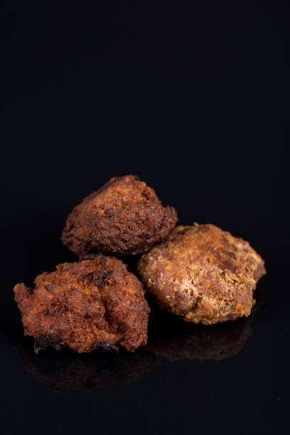 Meatballs isolated above black background with reflections and copy space