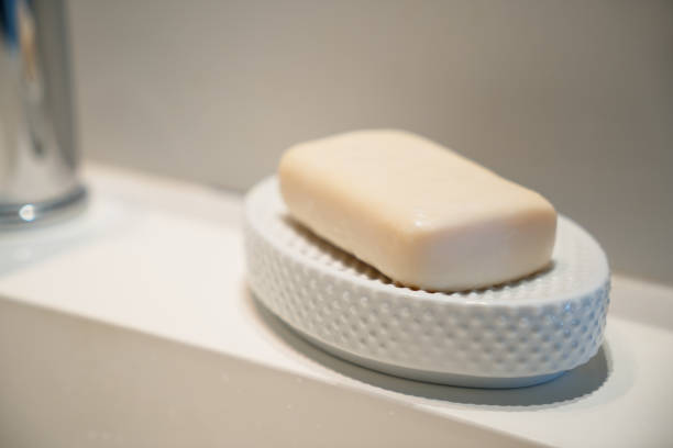 istock Yellow hand soap in a white ceramic soap dish sitting on a modern white sink 1216143988