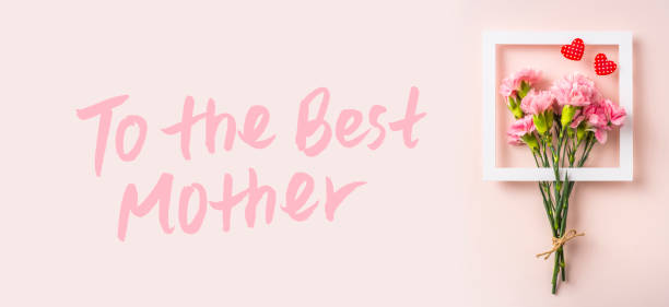 Design concept - top view of bunch of beautiful carnation with handwriting calligraphy and photo frame on pink background for mother day