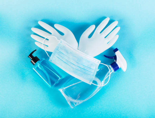 Masque médical, liquide de désinfection, savon, gants en latex sur fond bleu. Concept de protection du coronavirus. Protégez-vous et préparez-vous pour le coronavirus - Photo